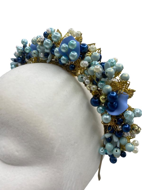 Stunning hand beaded multi-tonal blue crown with gold hardware detail.